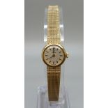 A lady's 9ct gold Omega wristwatch on an integrated 9ct gold bracelet strap, total weight with