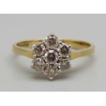 An 18ct gold, seven stone brilliant cut diamond cluster ring, London hallmark, band stamped 0.75cts,