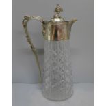 A cut glass claret jug with silver plated top