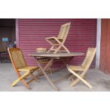 A circular teak garden table and four chairs