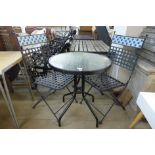 A small black metal and glass topped garden table and two chairs