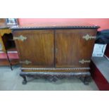 A Chippendale Revival carved mahogany press cupboard on a stand