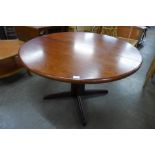 A circular teak dining table