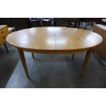 An oval teak extending dining table