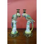 A pair of porcelain ormolu parrot candle stands