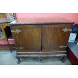 A Chippendale Revival carved mahogany press cupboard on a stand