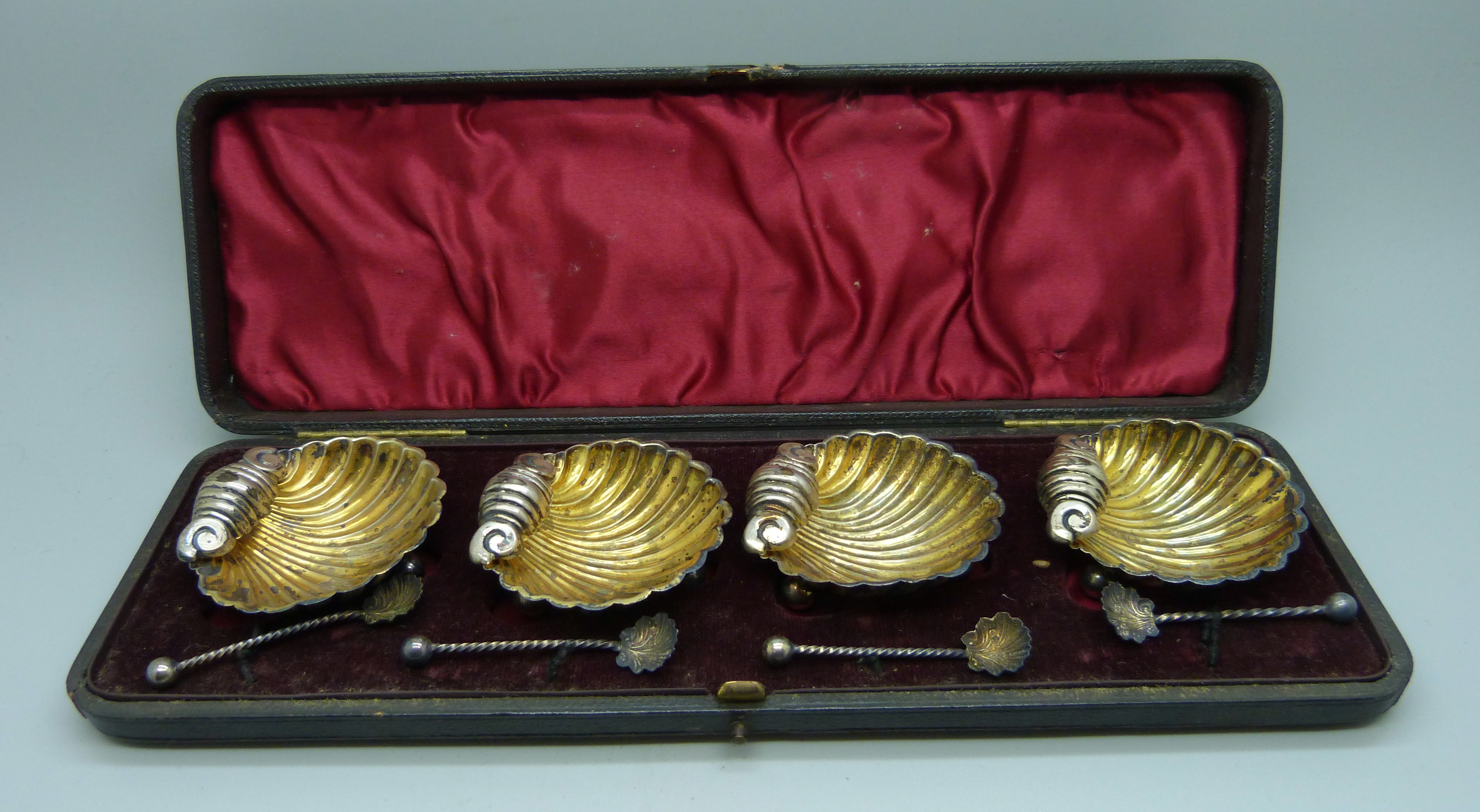 A Victorian cased set of four silver shell shaped salts and four salt spoons, Chester and