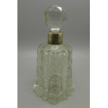 A large cut glass perfume bottle with silver collar