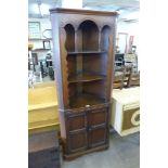 An oak freestanding corner cabinet