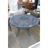 A circular cast alloy garden table