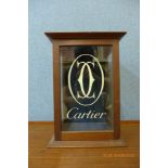 An oak counter top shop cabinet, bearing Cartier inscription to door