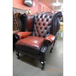 An oxblood red leather Chesterfield wingback armchair