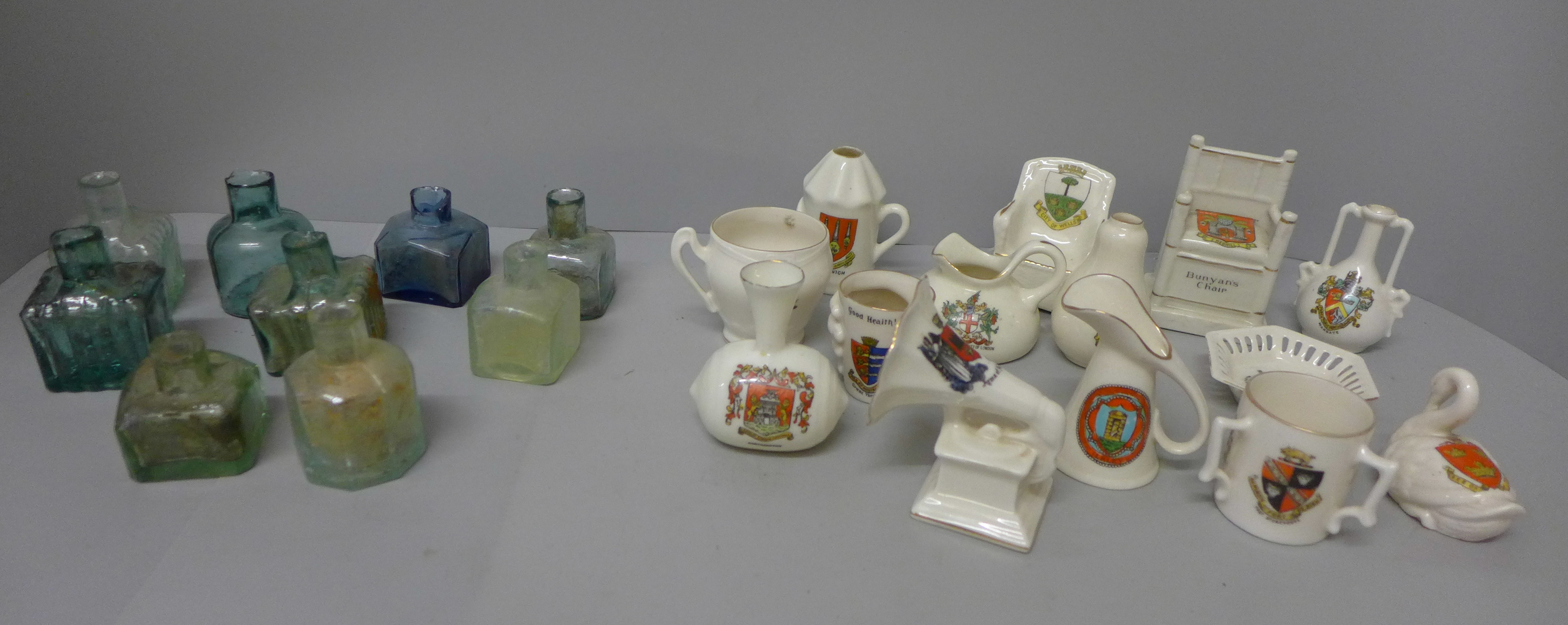 A collection of coins, tea cards, crested ware and glass bottles