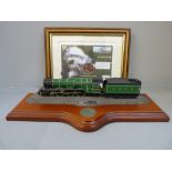 A commemorative Flying Scotsman coin cover and model on wooden plinth