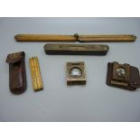 A folding ruler, a Coopers' gauge, two brass folding magnifying glasses and a spirit level