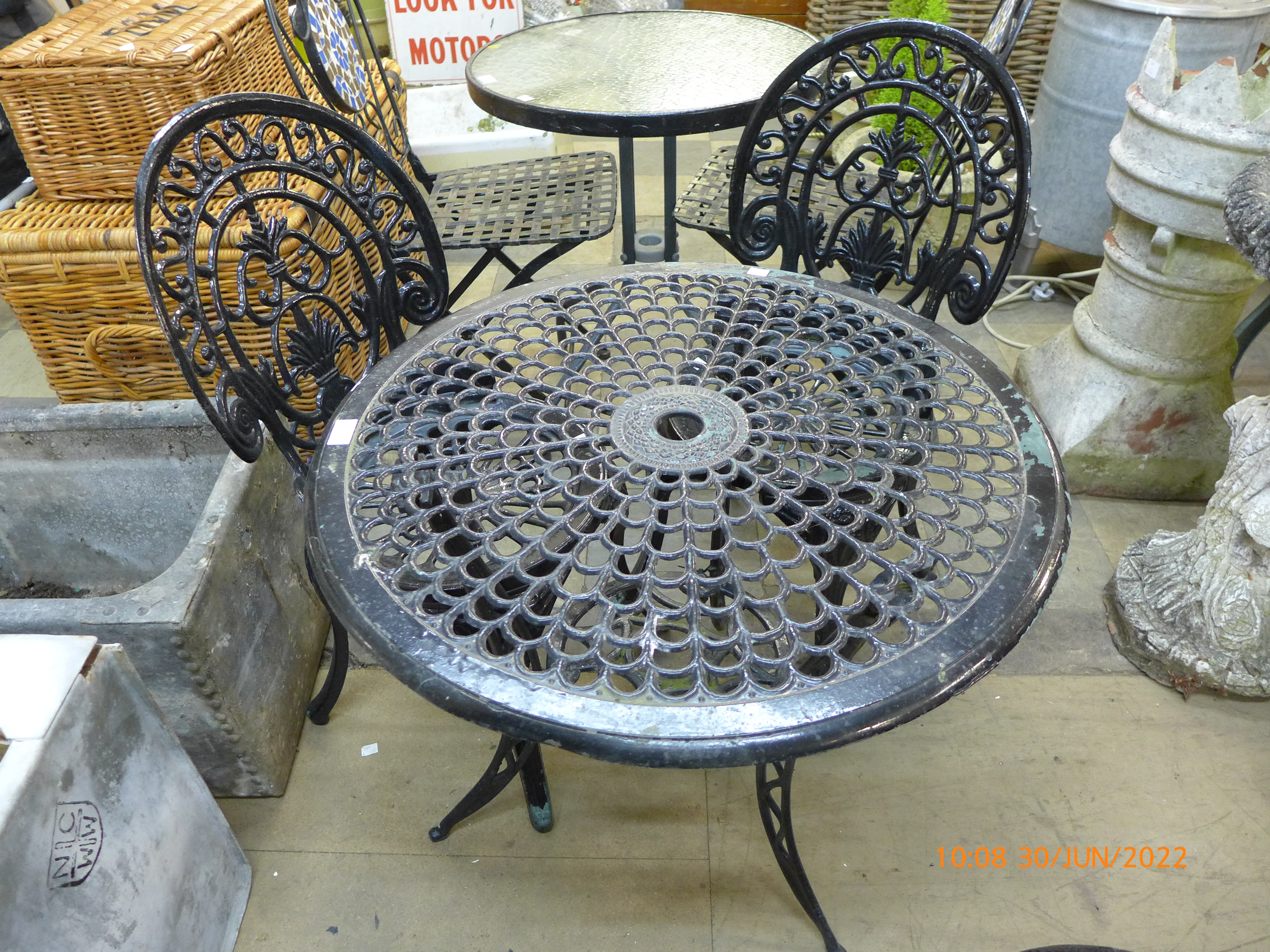 A painted cast alloy garden table and a pair of cast iron chairs