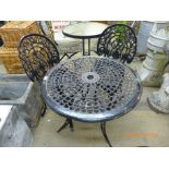 A painted cast alloy garden table and a pair of cast iron chairs
