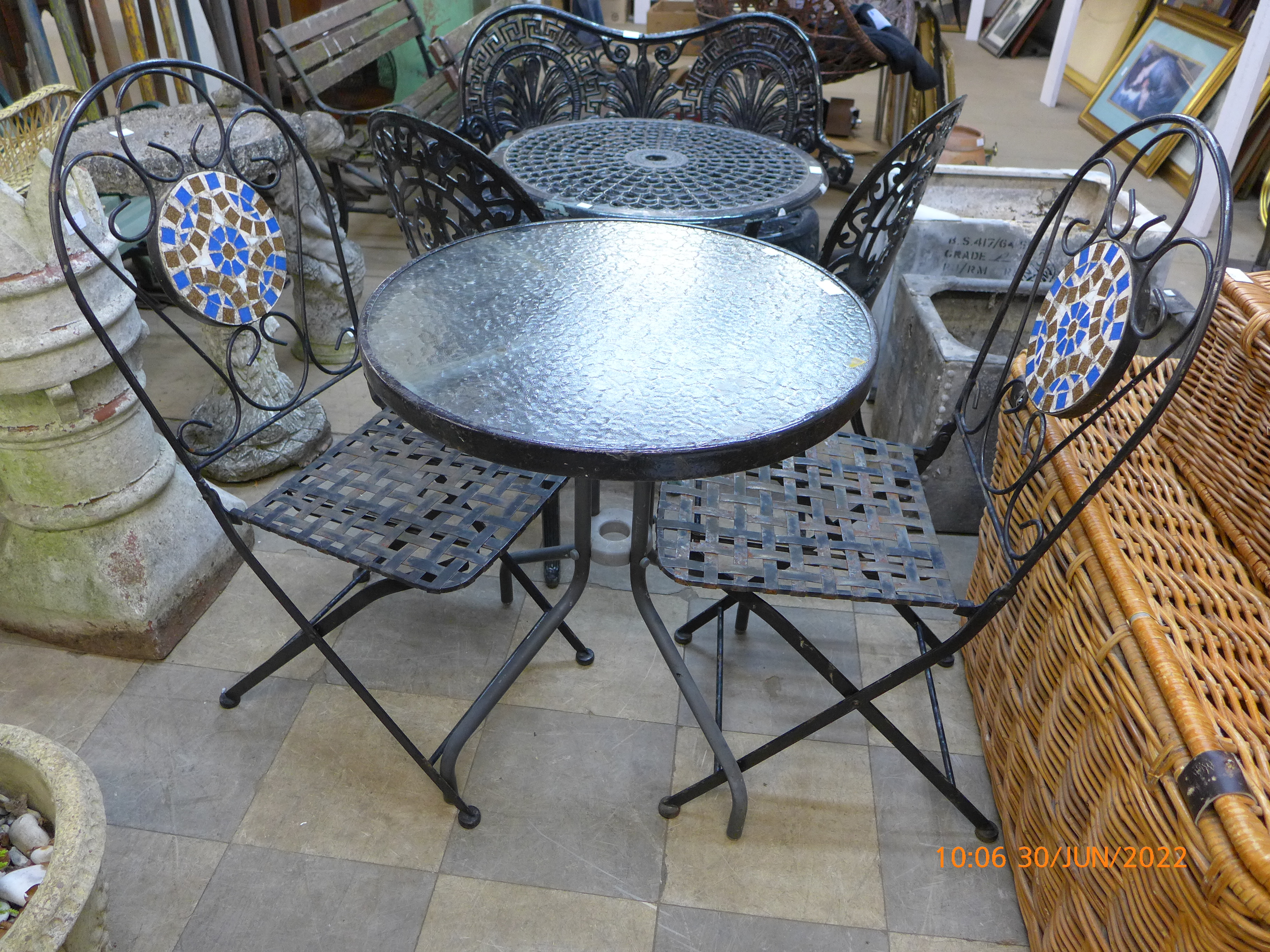 A circular metal and glass garden table and two chairs