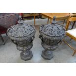 A pair of large Italian style bronze campana shaped urns and covers, cast with Bacchanalian cherubs