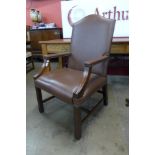 A mahogany and brown leather library armchair