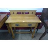 An Arts and Crafts carved oak single drawer side table