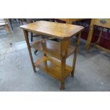 An Arts and Crafts oak three tier occasional table