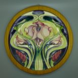 A framed Moorcroft charger, Art Nouveau Stylised Flower, designed by Emma Bossons 2004, design