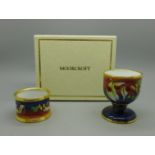 A Moorcroft handkerchief flower enamel egg cup and napkin ring, boxed