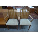 A pair of teak elbow chairs