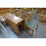 A teak drop leaf table and three oak chairs