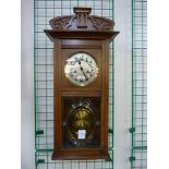 An early 20th Century oak wall clock