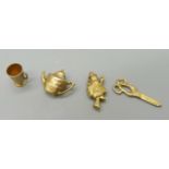 Four 9ct gold charms; teapot, drinking cup, pair of scissors and witch on a broom, 2.7g