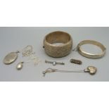 A silver bangle, a large white metal bangle, three silver lockets, etc.