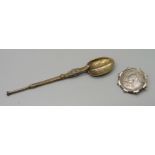 A silver spoon and a Victorian 1887 coin in brooch mount