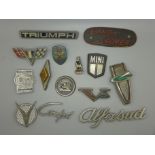 A collection of car badges including Mini, Alfa Sud, Land Rover plaque, old Volkswagen, Renault
