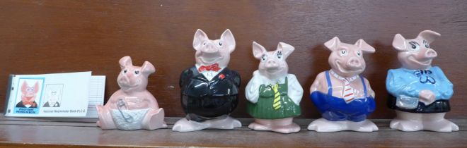 A set of five Nat West pig money banks, with cheque book