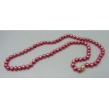A string of pink pearls with a 9ct gold clasp