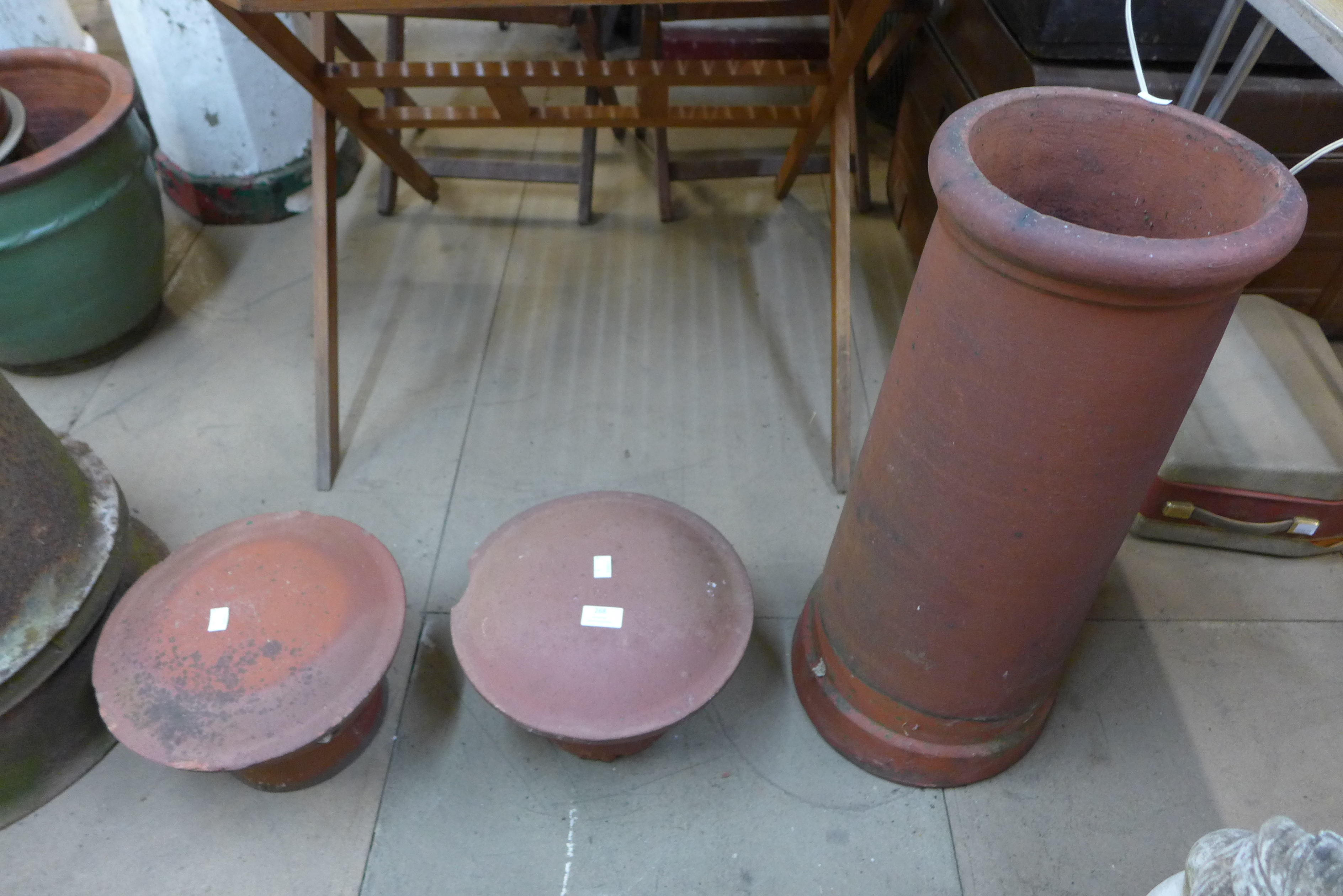 A terracotta chimney pot and a pair of terracotta chimney caps