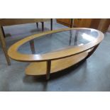 An oval teak and glass topped coffee table