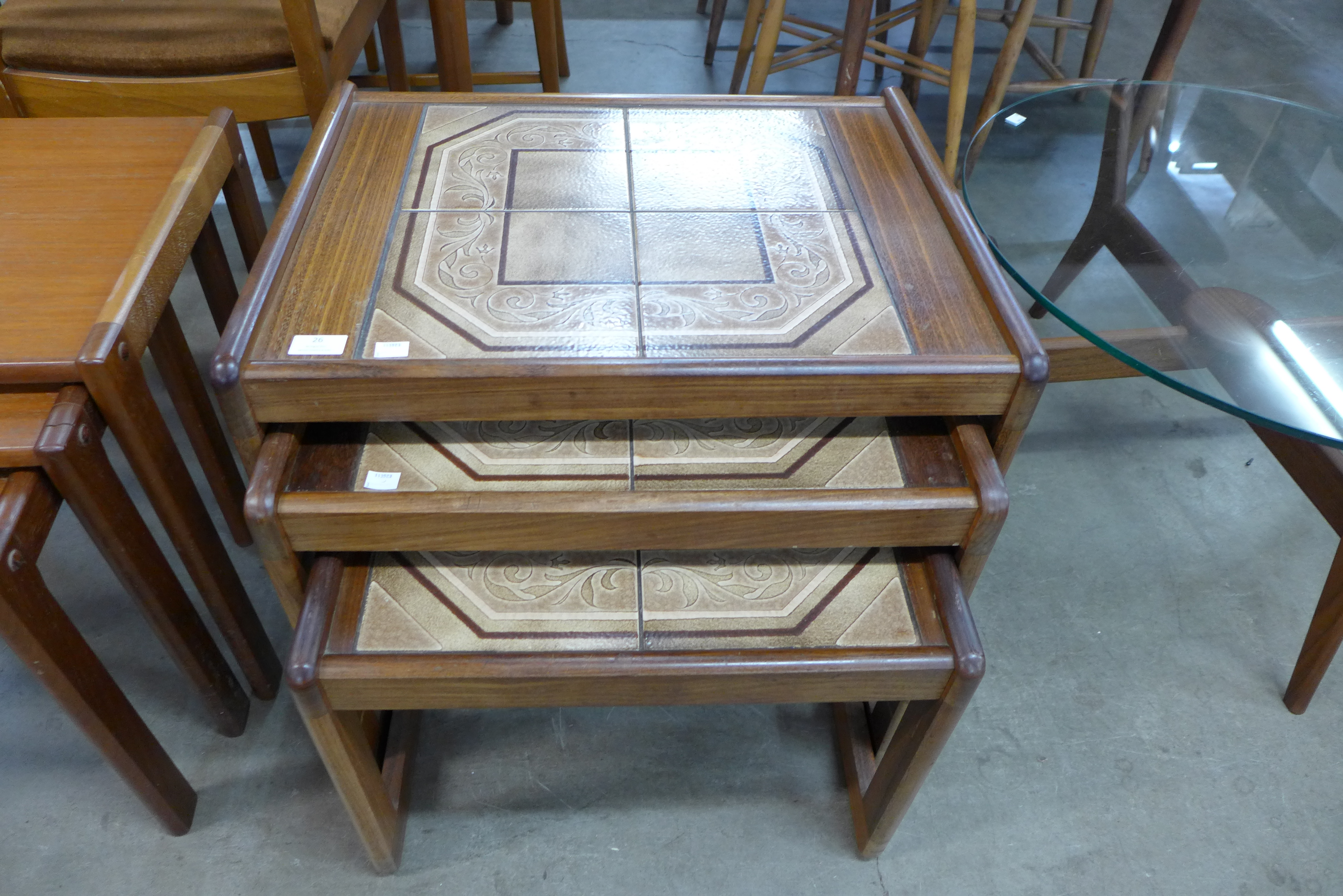 A teak and tiled top nest of tables