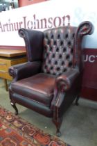 An oxblood red leather Chesterfield wingback armchair