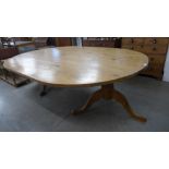 A large oval pine pedestal dining table