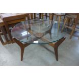 A circular teak and glass topped coffee table