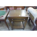 A carved oak single drawer side table