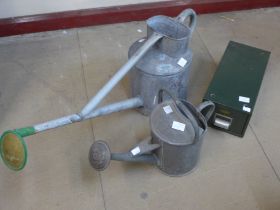 Two galvanised watering cans and a table top index drawer