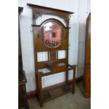 An Art Nouveau carved oak mirrored hall stand