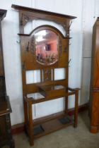 An Art Nouveau carved oak mirrored hall stand