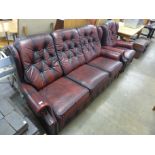 A red leather buttoned sofa and armchair
