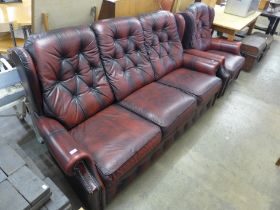 A red leather buttoned sofa and armchair