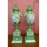 A pair of Italian style green porcelain and gilt vases and covers, decorated with romantic scenes